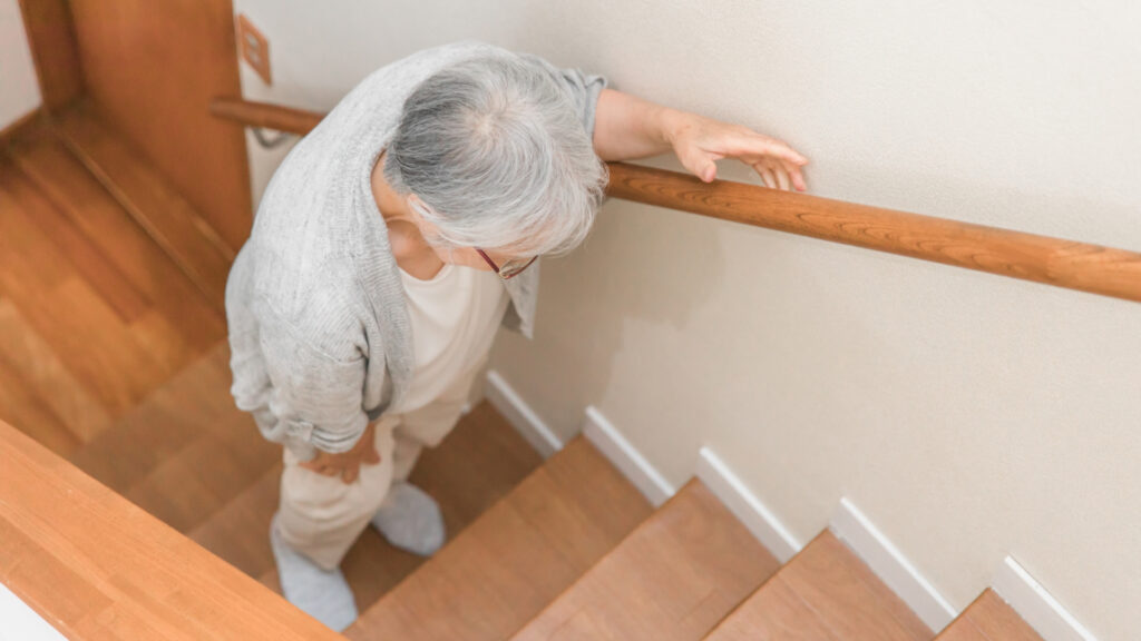 階段を登る高齢者女性