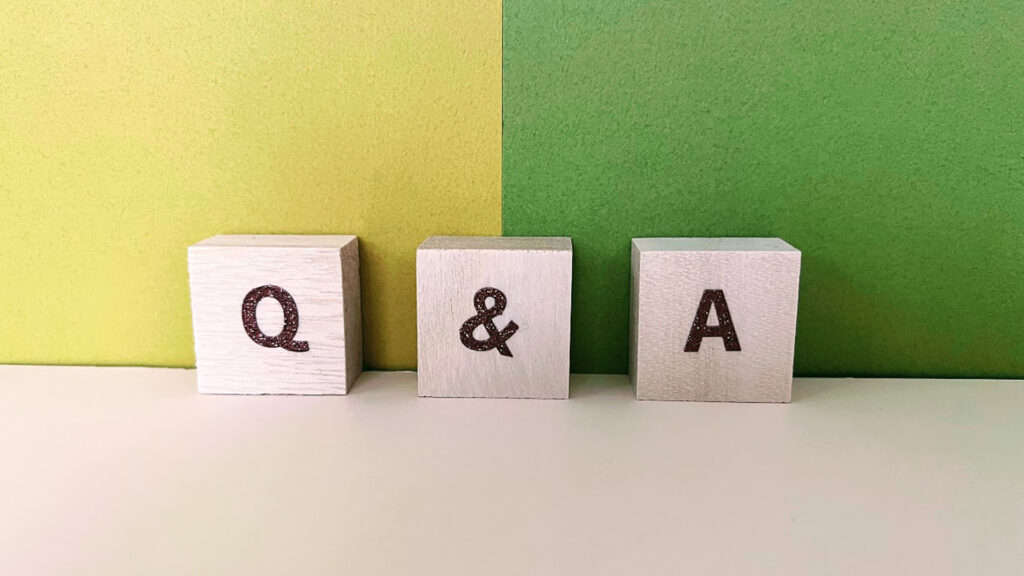 青と黄色の背景に置かれたQ&A木製ブロック