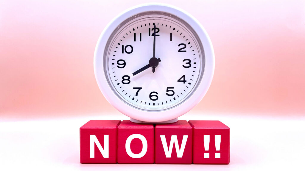 時計と「NOW!!」と書かれた赤いブロック