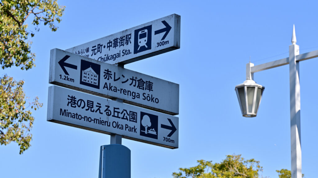 青空の下の横浜中華街駅への案内標識