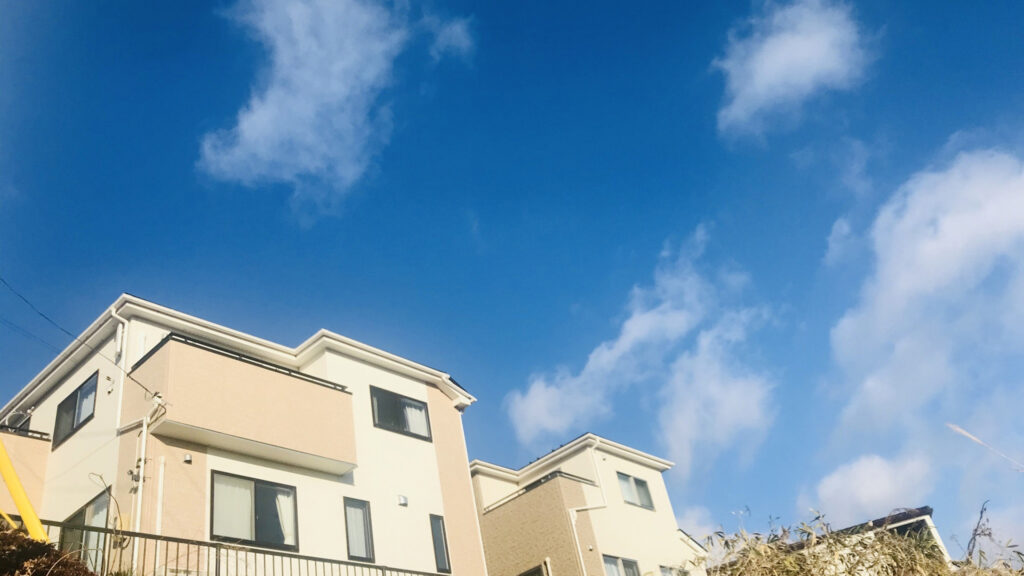 ベージュ色の住宅の外観と青空