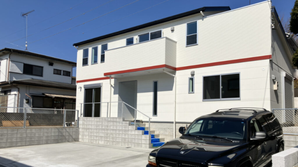 白を基調に赤のラインが入ったモダンな住宅