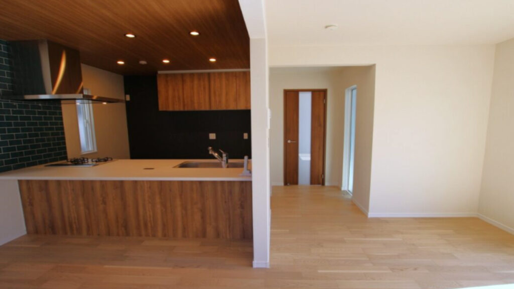 木製の床とキッチンが現代的な住宅のリビングダイニング